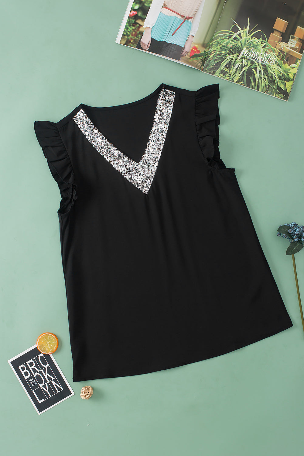 Blusa negra con manga acampanada y cuello en V con lentejuelas en contraste