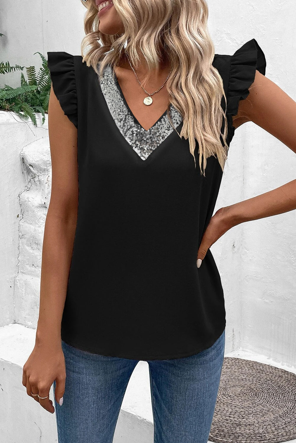 Blusa negra con manga acampanada y cuello en V con lentejuelas en contraste